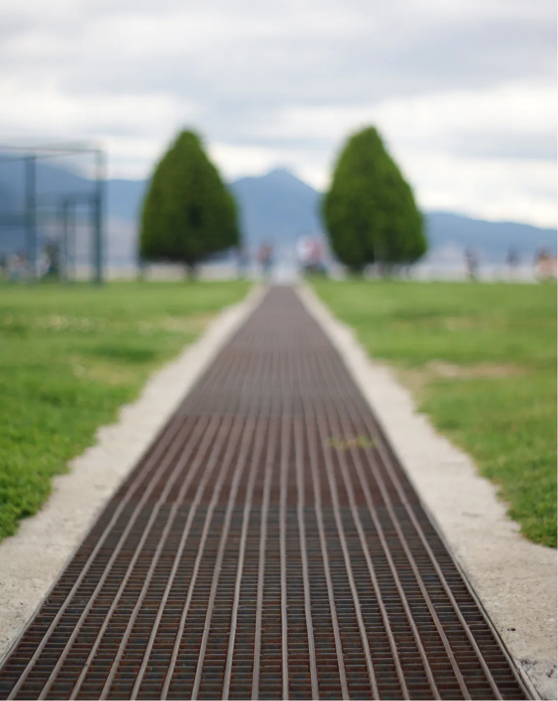 drain-2 A square black metal drain cover set in stone pavement with diagonal slats.