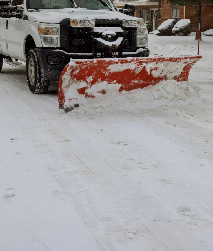 snow-removal-1 A snowplow truck clearing snow from a residential street on a winter day.